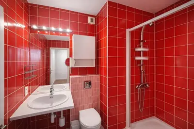 a red tiled bathroom with a toilet and a sink at Alhambra hideaway prime location in Brussels