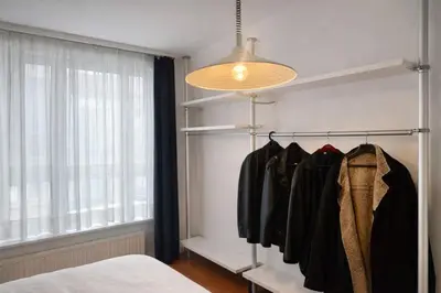 a bedroom with a rack of clothes next to a window at Alhambra hideaway prime location in Brussels