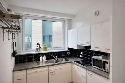 a white kitchen with a sink and a window at Alhambra hideaway prime location in Brussels