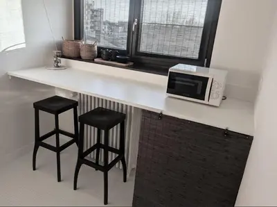 a kitchen with a counter with two stools and a microwave at Libertypenthouseghent - Monthly Stays - Miljoenenkwartier Gent in Ghent