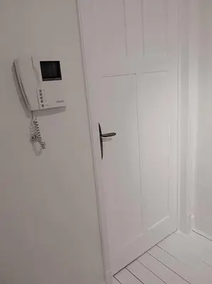 a white room with a door with a phone on it at Libertypenthouseghent - Monthly Stays - Miljoenenkwartier Gent in Ghent