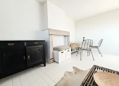 a living room with a black cabinet and a table and chairs at Libertypenthouseghent - Monthly Stays - Miljoenenkwartier Gent in Ghent