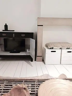 a living room with a bed and a television at Libertypenthouseghent - Monthly Stays - Miljoenenkwartier Gent in Ghent