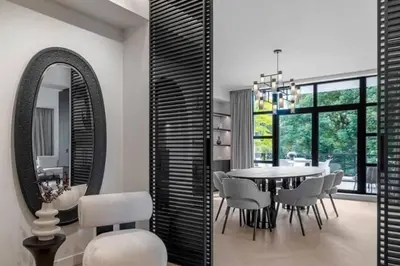 a dining room with a table and chairs and a mirror at Superb Apartment Pierson in Brussels