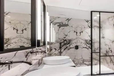 a bathroom with two sinks and a marble wall at Superb Apartment Pierson in Brussels
