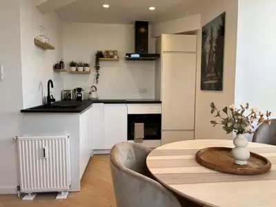 a kitchen and dining room with a table and chairs at Le Cozy Bijou in Antwerp