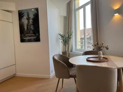 a dining room with a table and chairs and a window at Le Cozy Bijou in Antwerp