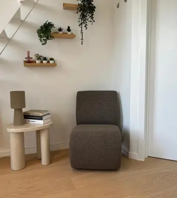 a chair and a side table in a room at Le Cozy Bijou in Antwerp