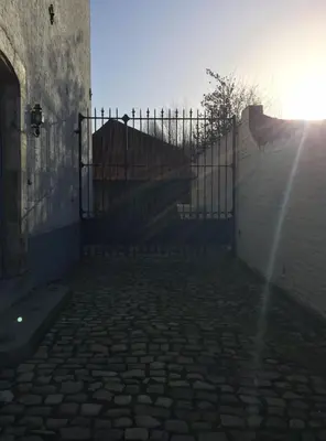 a gate with a fence in front of a building at Beautiful 19th-century house in the countryside in Glabbeek