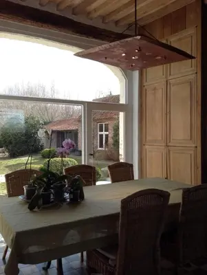 a dining room with a table and a large window at Beautiful 19th-century house in the countryside in Glabbeek