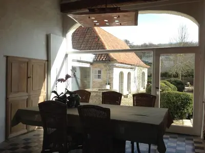 a dining room with a table and a large window at Beautiful 19th-century house in the countryside in Glabbeek