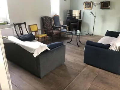 a living room with two couches and a table and chairs at Beautiful 19th-century house in the countryside in Glabbeek