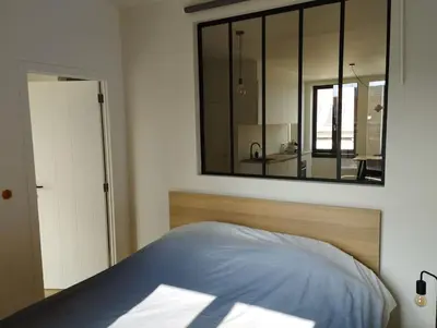 a bedroom with a large mirror above a bed at NiceFlatInTheStad in Antwerp
