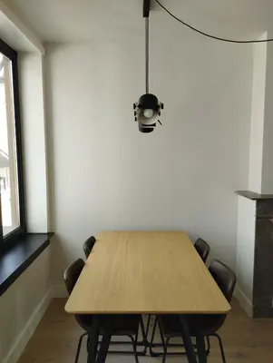 a dining room with a wooden table and chairs at NiceFlatInTheStad in Antwerp