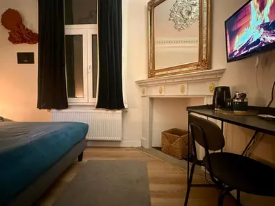 a bedroom with a bed and a mirror and a television at Luxury Rooms by Rikas Hotels in Antwerp