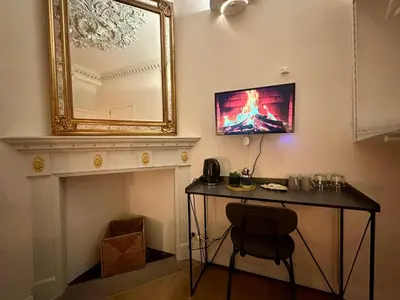 a room with a table and a mirror on the wall at Luxury Rooms by Rikas Hotels in Antwerp