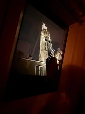 a view of a clock tower from a window at Luxury Rooms by Rikas Hotels in Antwerp