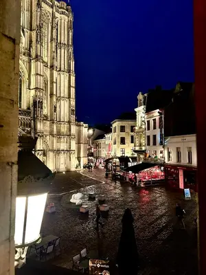 a city street at night with a large cathedral at Luxury Rooms by Rikas Hotels in Antwerp