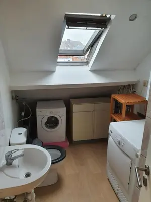 a bathroom with a toilet and a sink and a window at Studio meublé in Zaventem