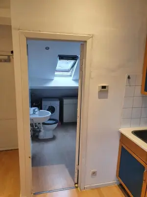 a bathroom with a toilet and a sink and a window at Studio meublé in Zaventem