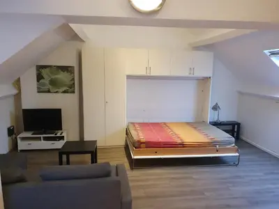 a bedroom with a large bed and a couch at Studio meublé in Zaventem