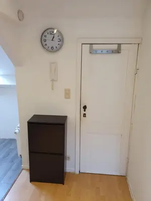 a clock on a wall next to a white door at Studio meublé in Zaventem