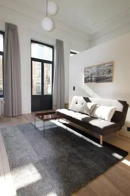 a living room with a couch and a coffee table at Canopée guesthouse in Brussels