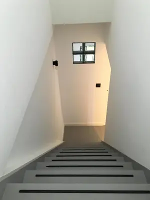 a staircase in an attic with a small window at Canopée guesthouse in Brussels