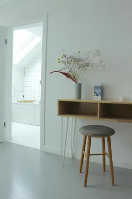 a table and a stool with a vase of flowers at Canopée guesthouse in Brussels