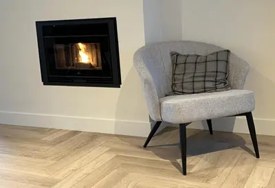a chair in a room with a fireplace at Parus major in Londerzeel