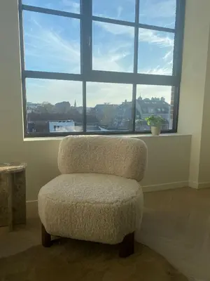a chair in a room with a large window at Verliefd in Antwerpen in Antwerp