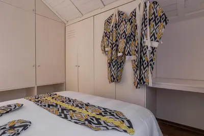 a room with a bed with shirts hanging on the wall at Kweni House in Brussels