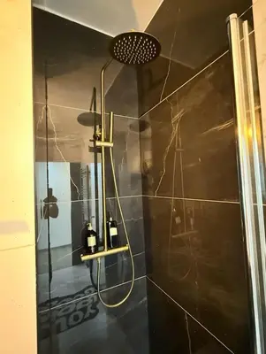 a bathroom with a shower with a glass door at Charming apartment in Bruxelles in Brussels