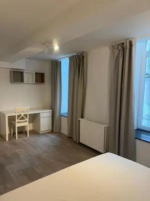 a room with a desk and a table and a window at Large 3-bedroom apartment in Bruxelles in Brussels