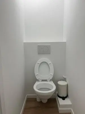 a white bathroom with a toilet with the lid up at Large 3-bedroom apartment in Bruxelles in Brussels
