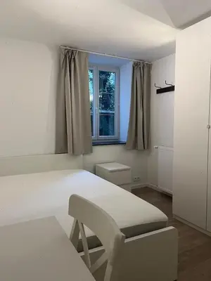 a white room with a table and a chair and a window at Large 3-bedroom apartment in Bruxelles in Brussels