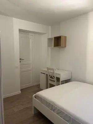 a white room with a bed and a desk and a chair at Large 3-bedroom apartment in Bruxelles in Brussels