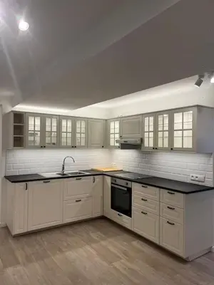 a kitchen with white cabinets and a black counter top at Large 3-bedroom apartment in Bruxelles in Brussels