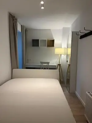 a bedroom with a white bed and a desk at Large 3-bedroom apartment in Bruxelles in Brussels