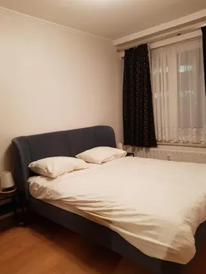 a bed with two pillows in a room with a window at Central cosy apartment in Brussels