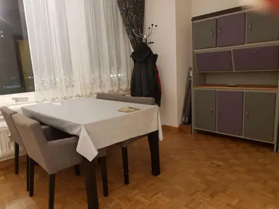 a dining room with a table and chairs and a dresser at Central cosy apartment in Brussels