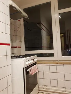 a white kitchen with a stove and a window at Central cosy apartment in Brussels
