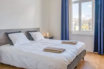 a bedroom with a large bed with two towels on it at Cozy & Bright Stay in Ghent - Parking Included in Ghent