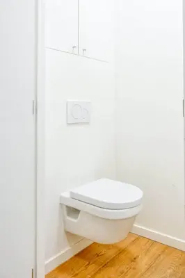 a white toilet in a bathroom with a wooden floor at Cozy & Bright Stay in Ghent - Parking Included in Ghent