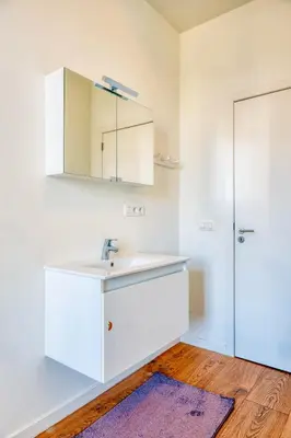 a white bathroom with a sink and a mirror at Cozy & Bright Stay in Ghent - Parking Included in Ghent