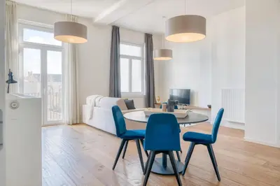 a living room with a table and blue chairs at Cozy & Bright Stay in Ghent - Parking Included in Ghent