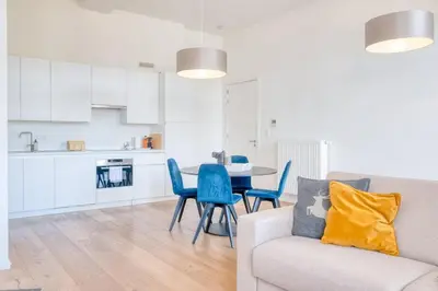 a kitchen and a living room with a couch and a table at Cozy & Bright Stay in Ghent - Parking Included in Ghent