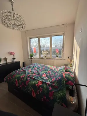 a bedroom with a bed with a floral comforter at Modern apartment in Brussels, ground floor in Brussels