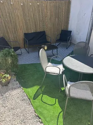 a patio with chairs and tables and grass at Modern apartment in Brussels, ground floor in Brussels