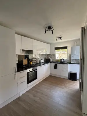 a kitchen with white cabinets and a wooden floor at Modern apartment in Brussels, ground floor in Brussels